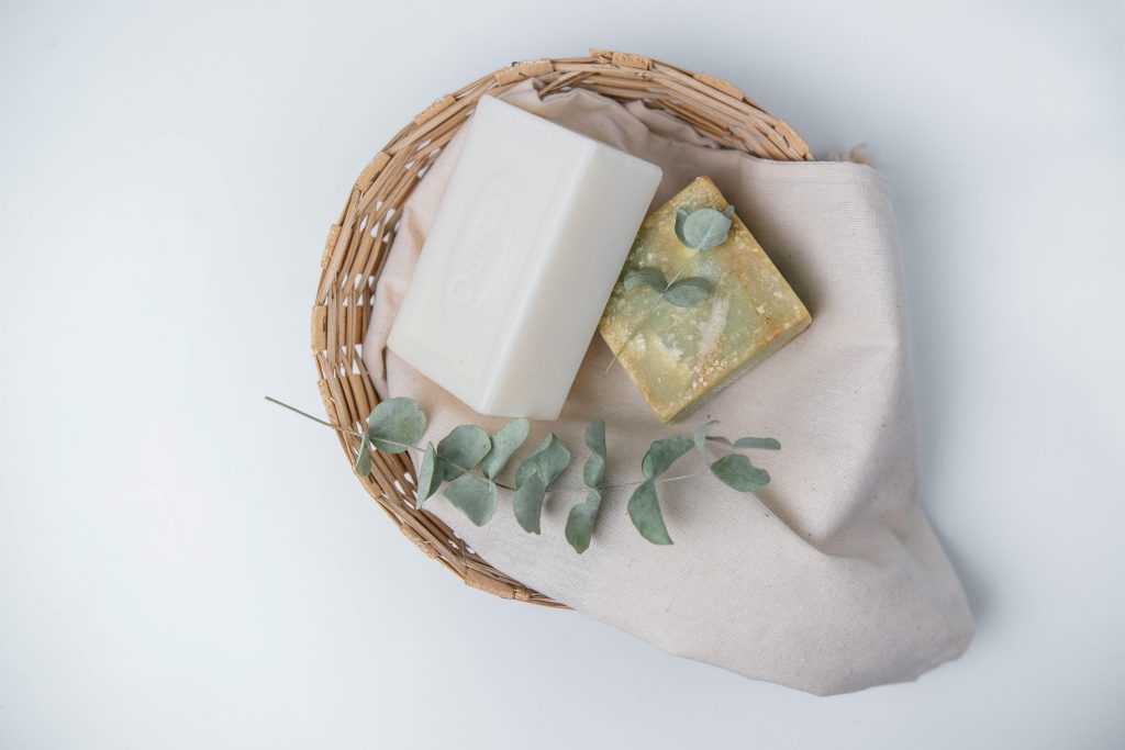 A natural, eco-friendly soap set with eucalyptus in a wicker basket, perfect for organic lifestyle promotions.