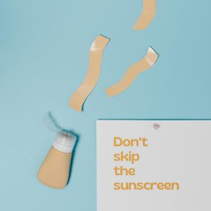 Minimalist flat lay design emphasizing the importance of sunscreen with a catchy slogan and bottle of sunscreen.