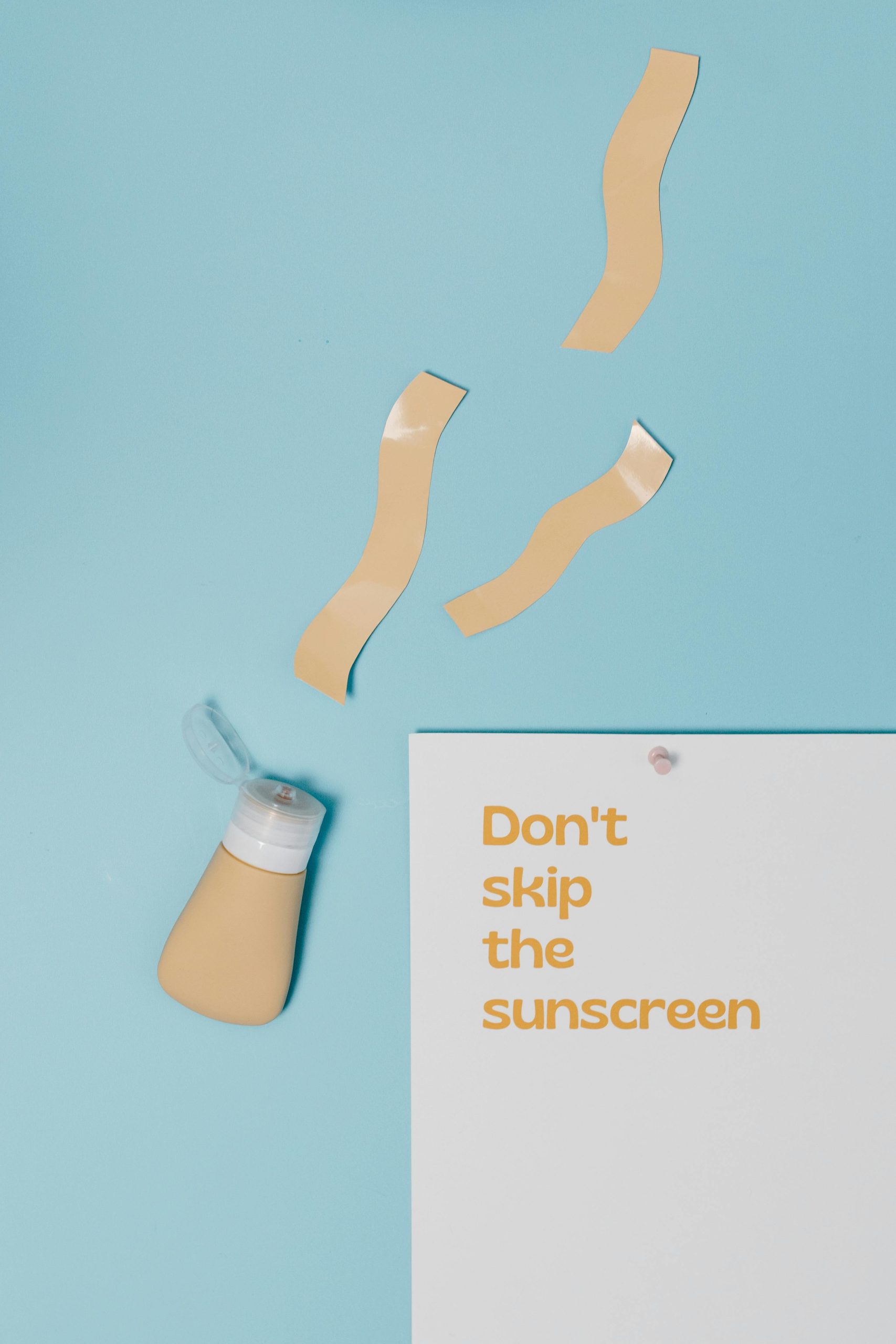 pexels photo 8384509 8384509 Minimalist flat lay design emphasizing the importance of sunscreen with a catchy slogan and bottle of sunscreen.